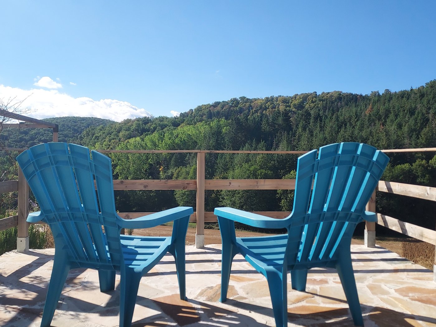 Chaises en terrasse face aux collines boisées